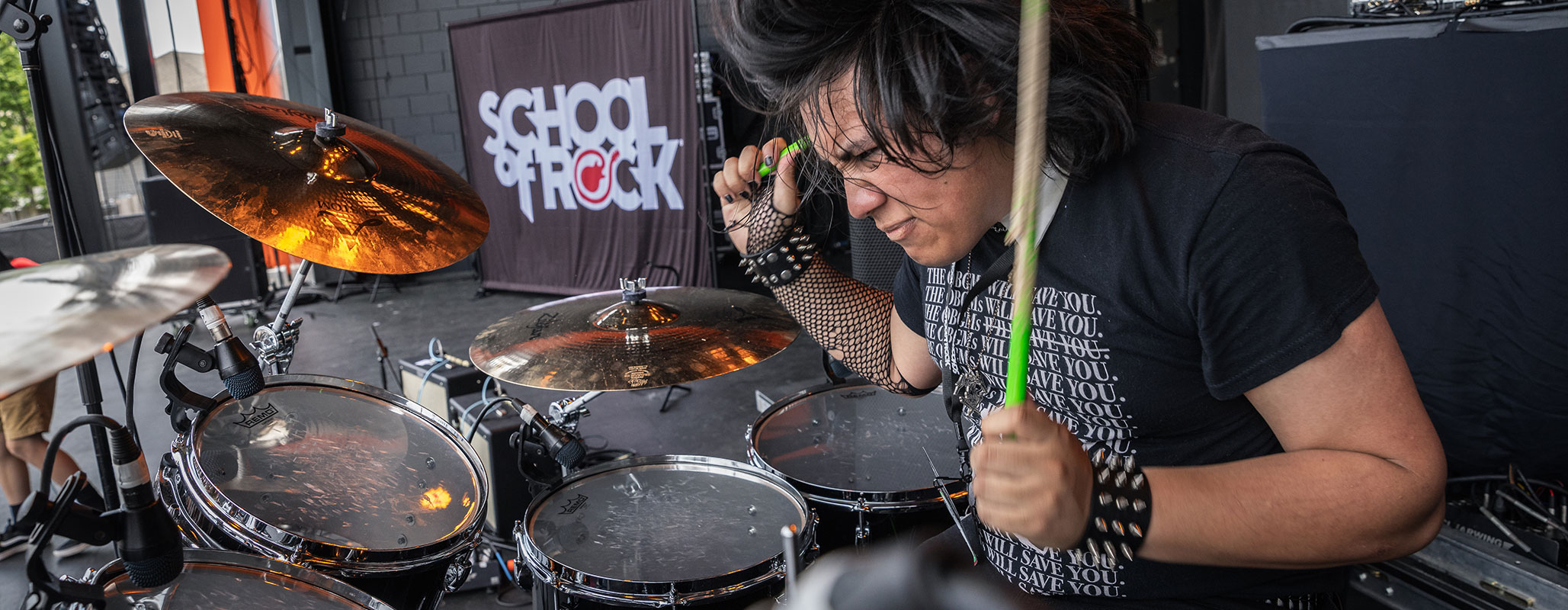 A School of Rock drum student exuding confidence on stage