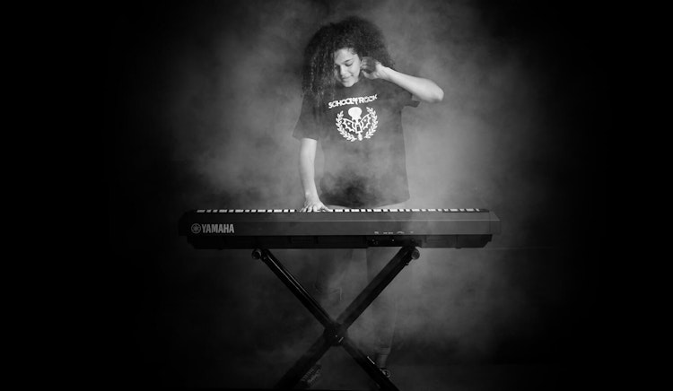 Student learning to play in School of Rock's performance program